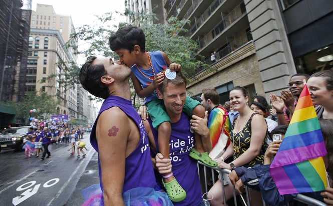 Rafael Gondim e Courtney King con loro figlio Gabriel King di cinque anni durante la marcia "Heritage Pride" a Manhattan, dopo la sentenza delle Corte Suprema a favore dei matrimoni gay negli Stati Uniti (AP Photo/Kathy Willens)